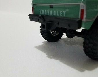 May include: Green Chevrolet pickup truck with a black rear bumper and black tires. The truck is on a white surface.