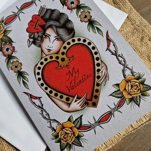 May include: Valentine's Day card featuring a vintage tattoo-style design. The card showcases a woman holding a heart with the words "My Valentine." The design includes roses, barbed wire, and a decorative border, all in a classic tattoo aesthetic.