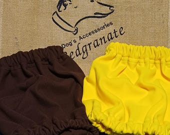 May include: Two pairs of dog accessories, one brown and one yellow, are displayed on a green cutting mat. The background features a burlap sack with a greyhound logo and the text "Dog's Accessories". The text "# greyhounds" is also visible.