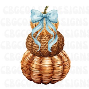 May include: A stack of three woven brown pumpkins with a light blue ribbon tied in a bow at the top. The pumpkins feature a textured, basket-like construction with a visible stem protruding from the center of the top pumpkin.
