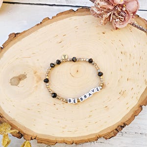 Pulseira de letras com contas pretas e douradas BE BRAVE
