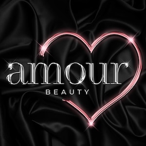 May include: A silver metallic logo with the word "amour" in a stylized font, with the word "beauty" underneath. The logo is set against a black satin background and is surrounded by a pink heart-shaped outline.