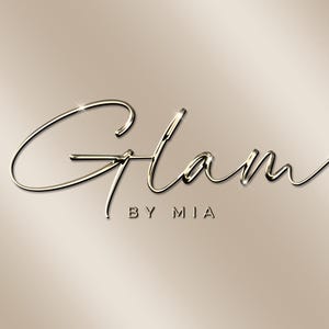 以下が含まれることがあります： 「Glam」という単語と、その下に「By Mia」というテキストが書かれた、金色の金属製のスクリプトロゴです。