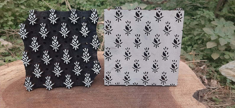 Op de afbeelding: Twee houten drukblokken met een bloemenmotief. De blokken zijn zwart en wit en hebben een reli&euml;fmotief. De blokken worden gebruikt voor het bedrukken van stoffen.