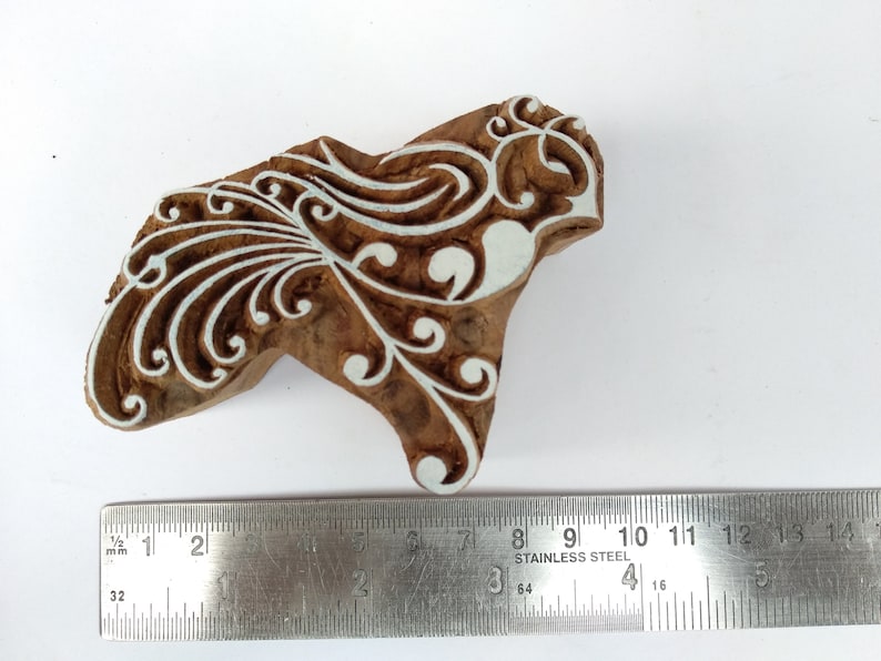 K&ouml;nnte beinhalten: Ein Holzblock-Stempel mit einem wei&szlig;en floralen Design. Der Stempel ist etwa 7,6 cm breit und 5,1 cm hoch.