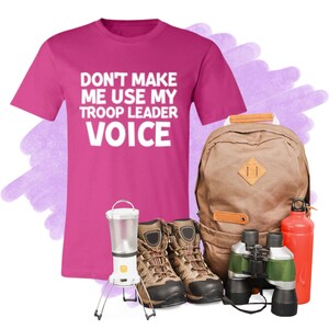 May include: Pink t-shirt with the text "Don't make me use my troop leader voice".  A brown backpack, a pair of brown hiking boots, a lantern, binoculars, and a red water bottle.