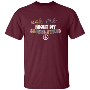 JEUNESSE Interrogez-moi sur mon cadeau de fin d'année de t-shirt de récompense de bronze Girl Scout Maroon
