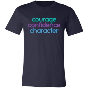 May include: Navy blue t-shirt with the words "courage", "confidence", and "character" printed in turquoise and purple.