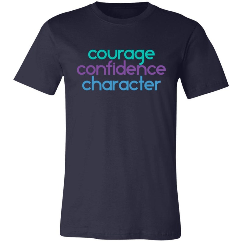 May include: Navy blue t-shirt with the words "courage", "confidence", and "character" printed in turquoise and purple.