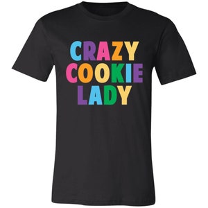 May include: Black t-shirt with the text "CRAZY COOKIE LADY" in rainbow colours.
