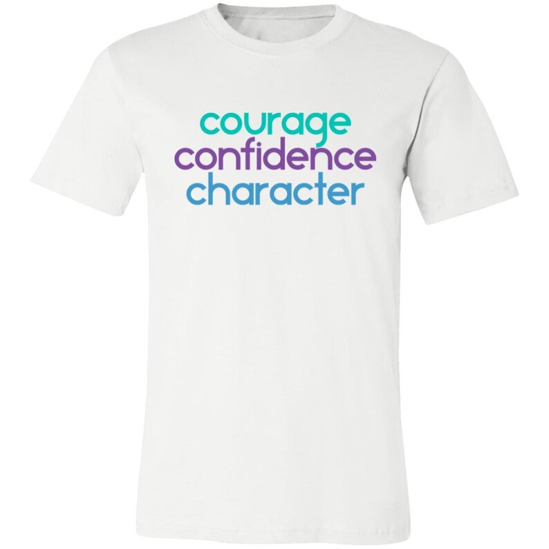 May include: White t-shirt with the words "courage", "confidence", and "character" printed in teal, purple, and blue.