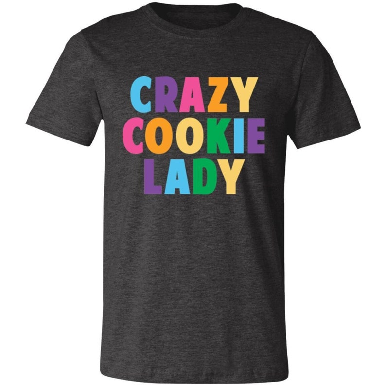 May include: A dark heather grey t-shirt with the text "CRAZY COOKIE LADY" in rainbow colours.