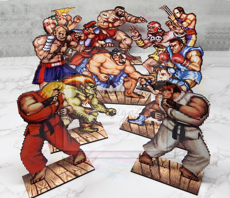 May include: A set of 10 colorful cardboard cutouts of characters from a popular video game. The characters are in various fighting poses and are depicted in a pixelated style.