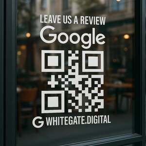 May include: A glass door displaying a white QR code and text. The words "LEAVE US A REVIEW" are above the Google logo. The text "WHITEGATE.DIGITAL" is below the QR code. The background is out of focus.