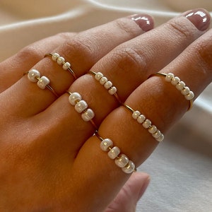 Simple golden anxiety ring with white pearls in freshwater pearl optics