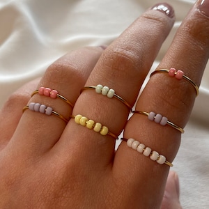 Simple golden anxiety rings with colorful pastel colored glass beads