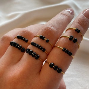 Simple golden anxiety rings with black glass beads