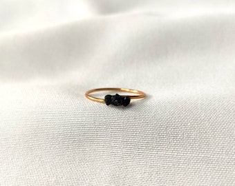 Simple gold ring with small black tourmaline stones