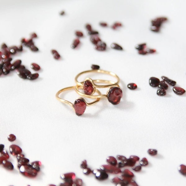Einfacher goldener Ring mit rotem Granat Edelstein