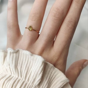 Simple gold ring with small green peridot stone