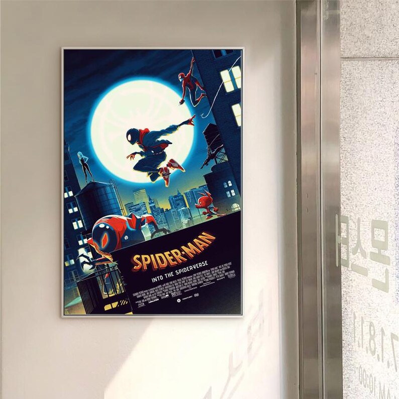 May include: A framed poster for "Spider-Man: Into the Spider-Verse" with Spider-Man characters in action against a cityscape. The poster features a large moon and the film's title text.