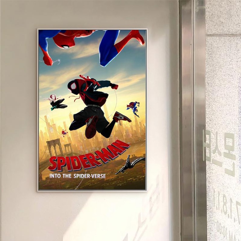 May include: A framed poster for the film Spider-Man: Into the Spider-Verse. The image shows various Spider-Man characters in dynamic poses against a cityscape backdrop, with the film's title in red and the tagline below.