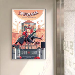 May include: A framed poster for Spider-Man: Into the Spider-Verse. The illustration shows Spider-Man in action against a city skyline, with spray paint cans in the foreground and the film's title prominently displayed.