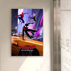 May include: A framed poster featuring characters from the animated film "Spider-Man: Into the Spider-Verse." The artwork shows three Spider-Man characters in dynamic poses against a city backdrop, with a yellow taxi cab in the foreground. The movie title is displayed.