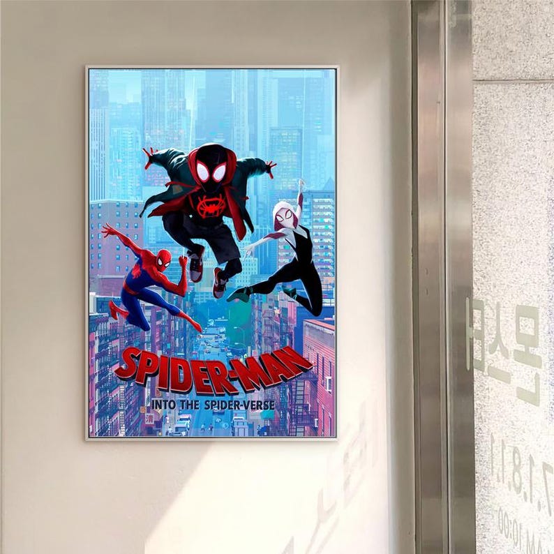 May include: A framed poster for the animated film "Spider-Man: Into the Spider-Verse." The image shows three Spider-Man characters in action against a city background. The film's title is written in large letters at the bottom of the poster.