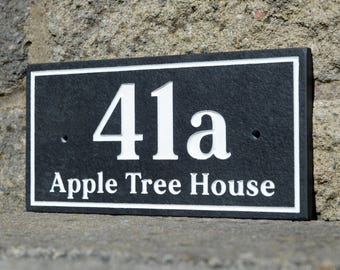 May include: A rectangular black address plaque with white lettering. The numbers "41a" are prominently displayed above the words "Apple Tree House". The plaque has a white border and is mounted on a stone surface.