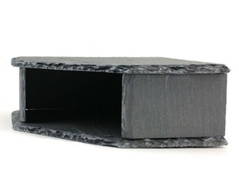 May include: A black slate box with a rectangular opening. The box is made of natural slate and has a rough, textured surface.