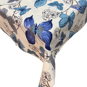 May include: A white tablecloth with a blue and brown butterfly pattern. The tablecloth has a floral design and is made of a soft, comfortable fabric.