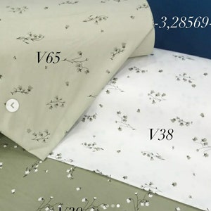 May include: Three fabric swatches with a floral pattern. The top swatch is a light green with a white floral pattern. The middle swatch is white with a gray floral pattern. The bottom swatch is a darker green with a white floral pattern. The swatches are labeled V65, V38, and V39.
