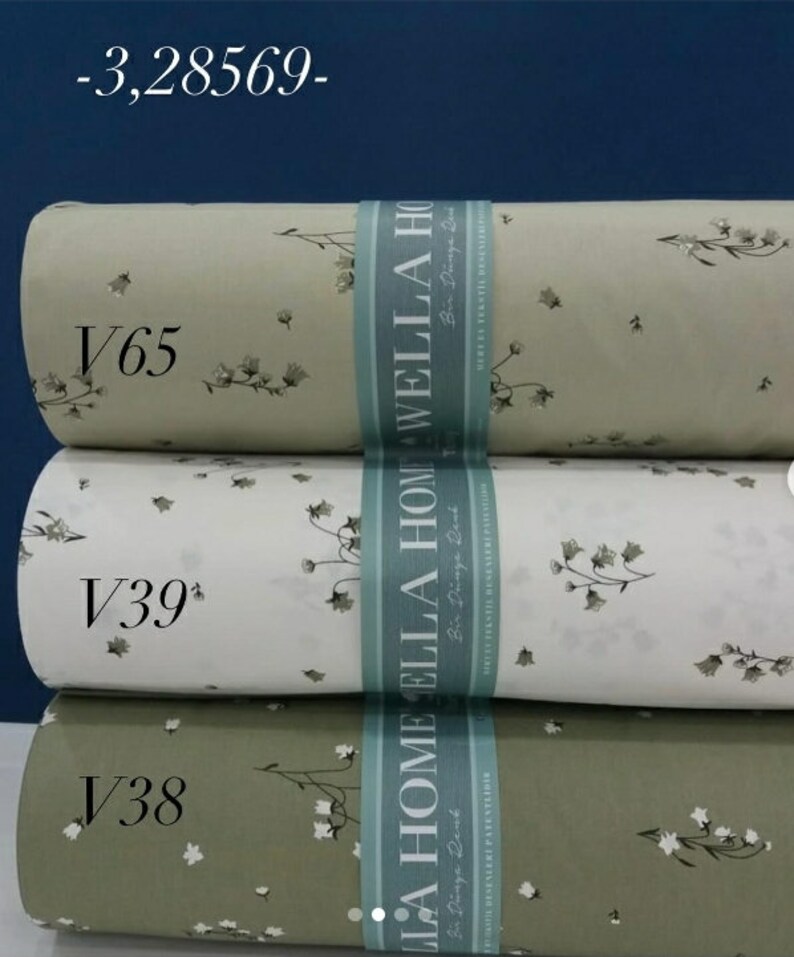 May include: Three rolls of fabric with a floral pattern. The fabric is in shades of green and white. The fabric is labeled with the text "LA HOME ELLA HOME WELLA HOME" and the text "Bir Dinga Bed".