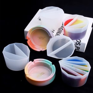 May include: Set of six silicone moulds for making resin ashtrays. The moulds are in various shapes, including round, square, and triangular. The moulds are clear and show the details of the finished product.
