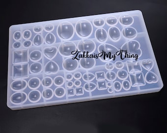May include: A clear silicone mold with various shapes for resin casting. The mold includes circles, ovals, squares, rectangles, and hearts. The mold is on a white surface. "Zakka is My Thing" is printed on the mold.