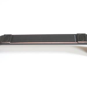 May include: Black cabinet pull with a copper finish and a decorative grooved design. The pull has a curved shape and rounded ends.