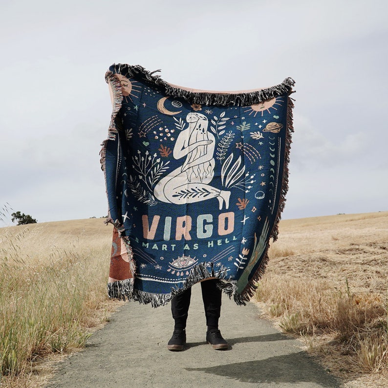 May include: A blue woven tapestry throw blanket with a Virgo zodiac sign illustration and the text "Smart as Hell". The tapestry features a woman holding a flower and stars.