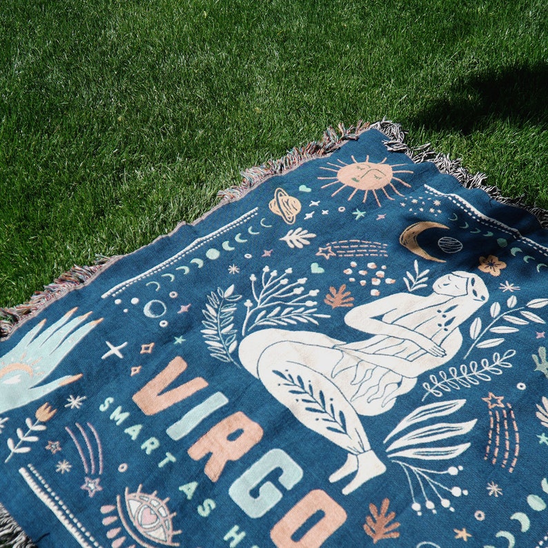 May include: A blue throw blanket with a white and pink design featuring a stylized Virgo zodiac sign, a woman, and celestial elements. The text "Smart as Hell" is included in the design.