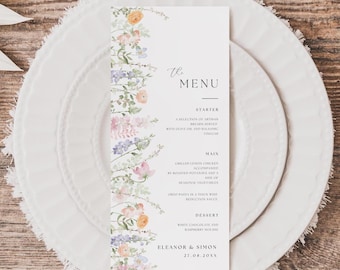 May include: A vertical white menu card featuring a watercolor floral border on the left side with orange, pink, and purple flowers. The text reads The Menu, Starter, Main, Dessert, and Eleanor & Simon 27.08.20XX in black serif and script fonts.