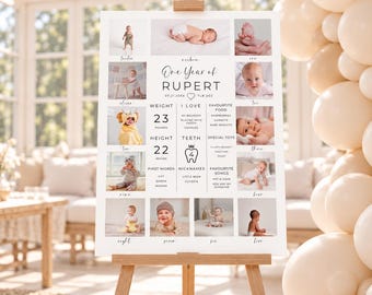 May include: A white milestone poster titled One Year of RUPERT, featuring twelve photographs of a baby, birth details, weight of 23 pounds, height of 22 inches, and lists of favorite foods, toys, songs, nicknames, and first words.