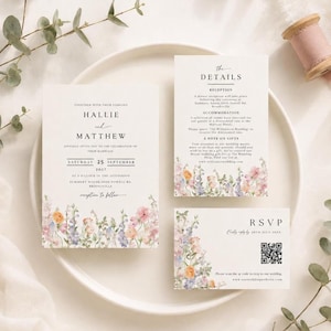 May include: A wedding invitation suite featuring three white cards with black serif text and watercolor wildflower illustrations in pink, orange, and blue. The set includes a main invitation, a details card, and an RSVP card with a QR code.