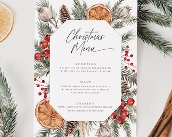 May include: A Christmas menu card with a white background, featuring the text "Christmas Menu" in elegant script. The card is decorated with pine needles, berries, pinecones, and dried orange slices. The menu lists starters, main course, and dessert.
