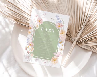 May include: A baby shower invitation with a green archway and floral design. The text reads "Baby in Bloom" and includes the name "Rachel Smith".