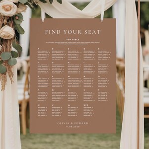 May include: A brown wedding seating chart with white text that reads "FIND YOUR SEAT" and "TOP TABLE". The names are organized alphabetically. The names Olivia & Edward and the date 11.08.2028 are at the bottom.