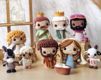 Puede incluir: Un belén de crochet con figuras de María, José, el niño Jesús, los tres reyes magos, una oveja, un burro y una vaca. Las figuras están todas vestidas con ropa tradicional y tienen rasgos detallados.
