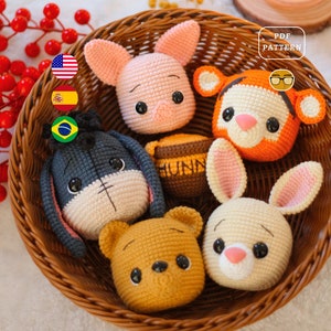 May include: A wicker basket filled with crocheted stuffed animals, including a pig, a tiger, a donkey, a bear, and a bunny. The animals are all in a sitting position and have large, expressive eyes. The basket is sitting on a table with a red berry branch in the background.