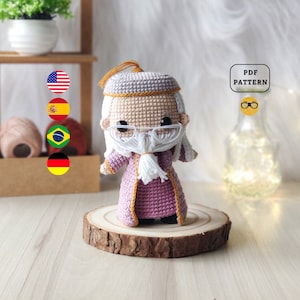 Peut inclure: Patron de crochet amigurumi pour un sorcier avec une longue barbe blanche, portant une robe violette avec des bordures dorées et un chapeau gris. Le patron est disponible en téléchargement PDF.