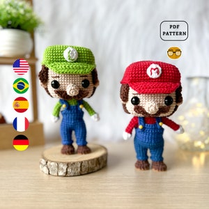 May include: Two crocheted figures of Mario and Luigi, both wearing their signature overalls and hats. Mario is wearing a red hat with an 'M' on it, and Luigi is wearing a green hat with an 'L' on it. The figures are standing on a wooden surface.