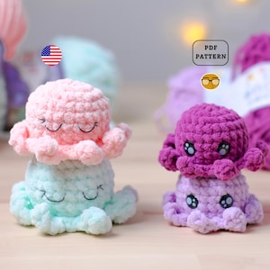 Op de afbeelding: Twee gehaakte octopus amigurumi speelgoedjes. Eén is roze en de andere is paars. Beide hebben zwarte ogen en een glimlachende mond. De roze octopus ligt op een lichtblauwe octopus. De speelgoedjes liggen op een houten oppervlak. PDF-PATROON
